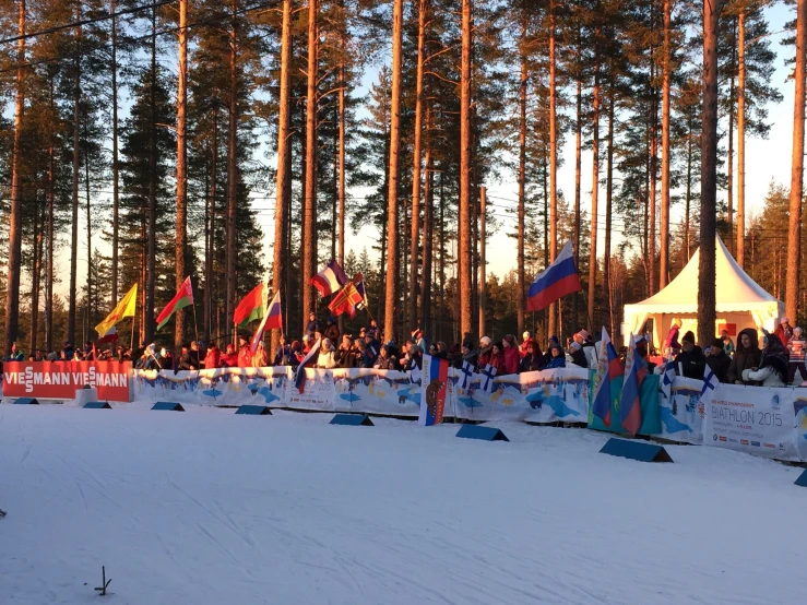 people standing in the snow by some flags