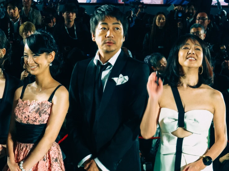 three asian people standing together at an event