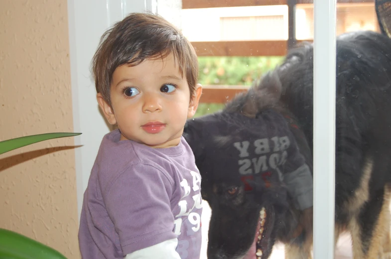 small child with blue eyes looking out the window