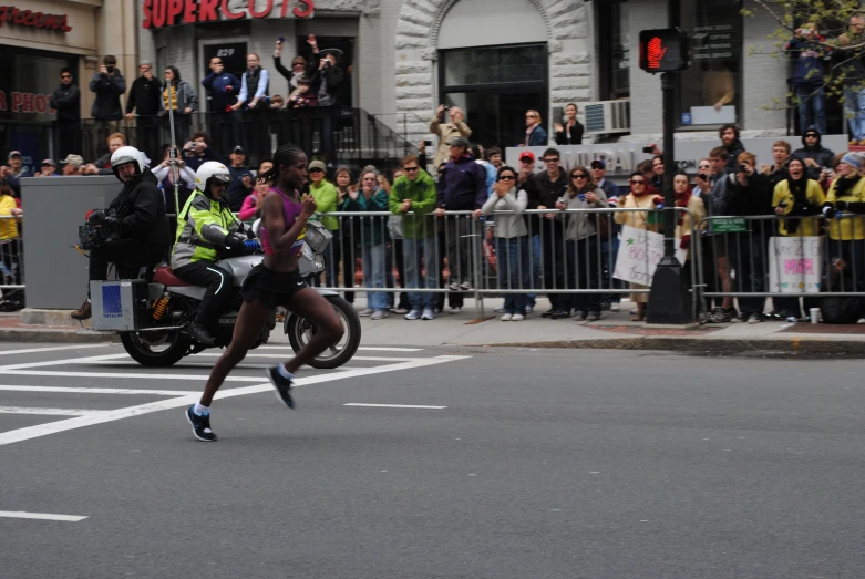 there is a marathon participant riding a motorcycle behind a crowd