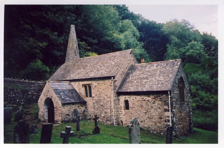 an old church with stone walls surrounded by trees