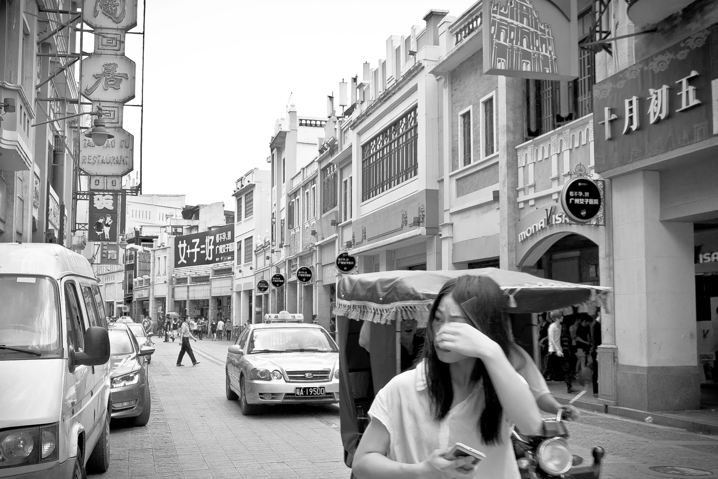 a girl walking down a crowded street holding a umbrella