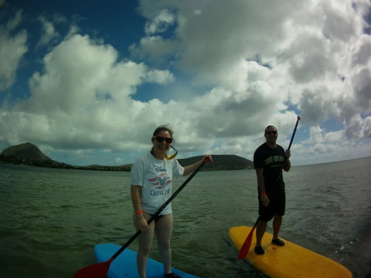 a man standing on a surf board with a paddle