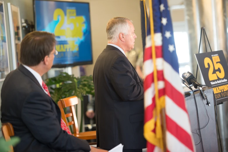 the man in a suit and tie is giving a speech