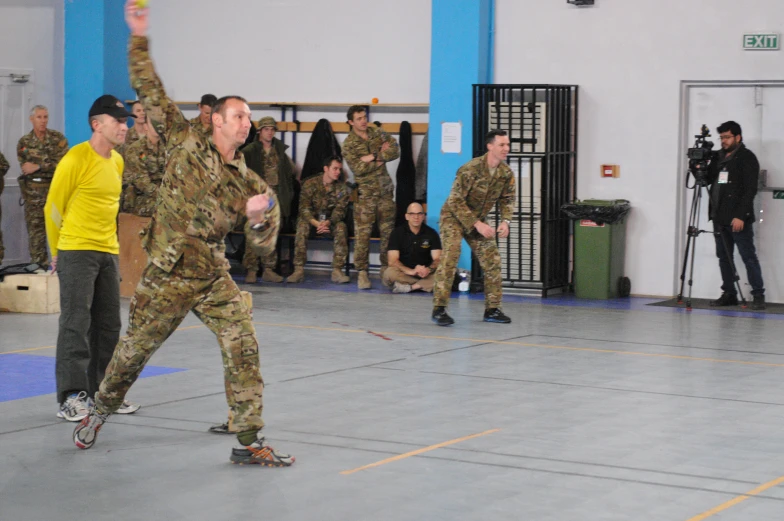 men in army uniforms are playing wii together