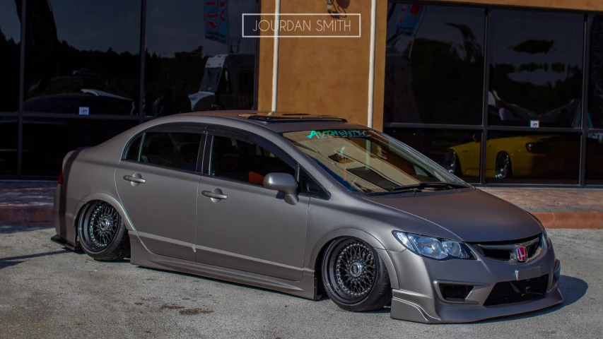 the grey car is parked in front of a building