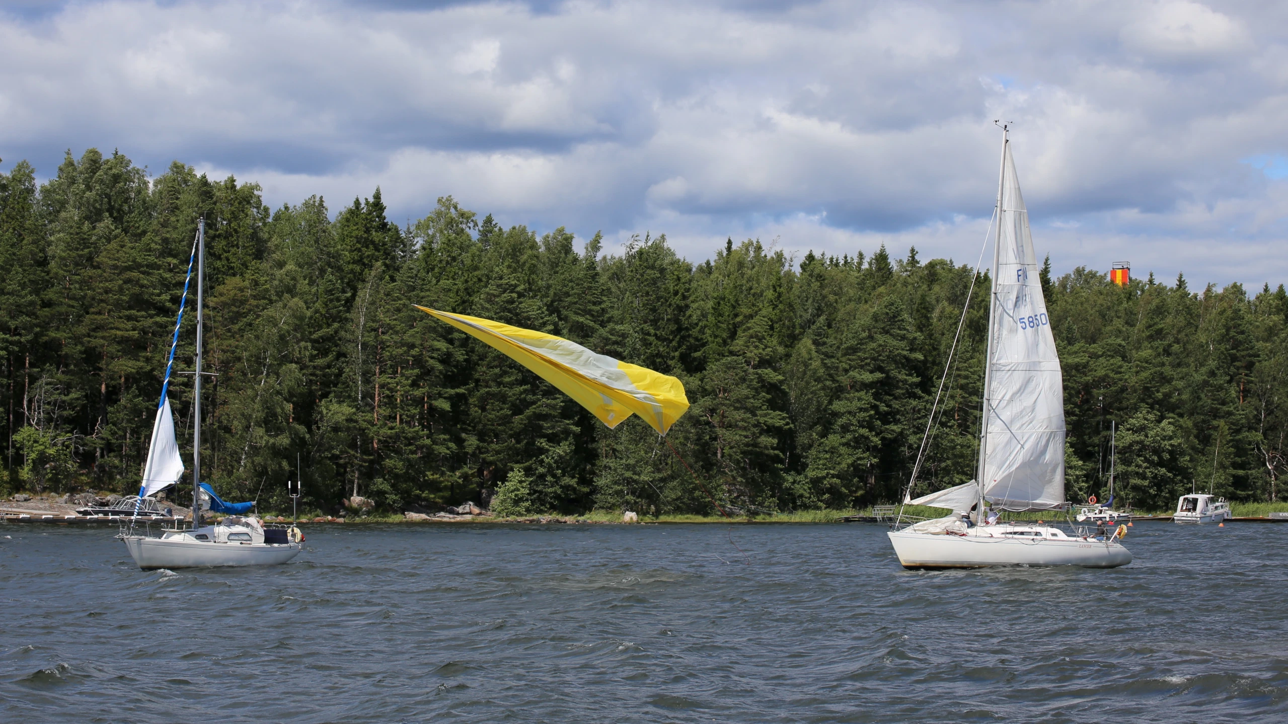 two boats are on the water next to some trees