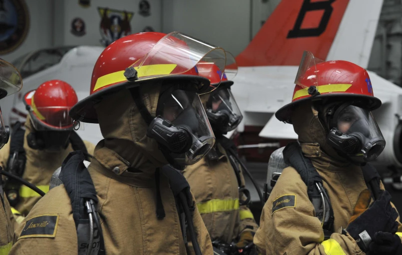 a group of firemen in protective gear with helmets on