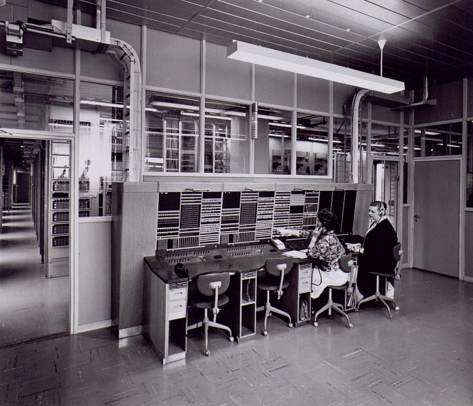 two people sitting at a long table in front of shelves