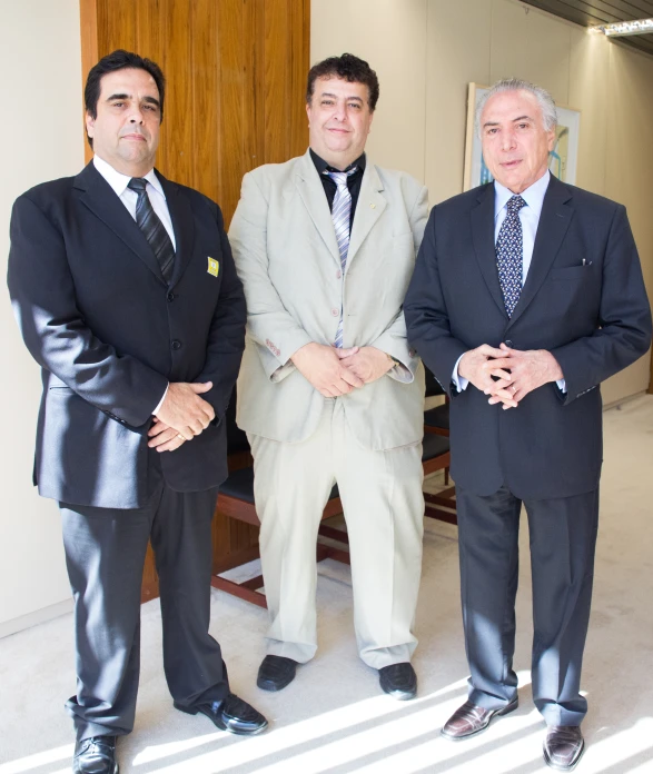 three men posing together in suits and ties