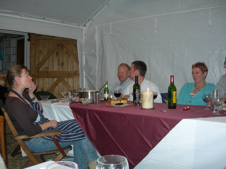 a group of people sitting at a table and wine glasses