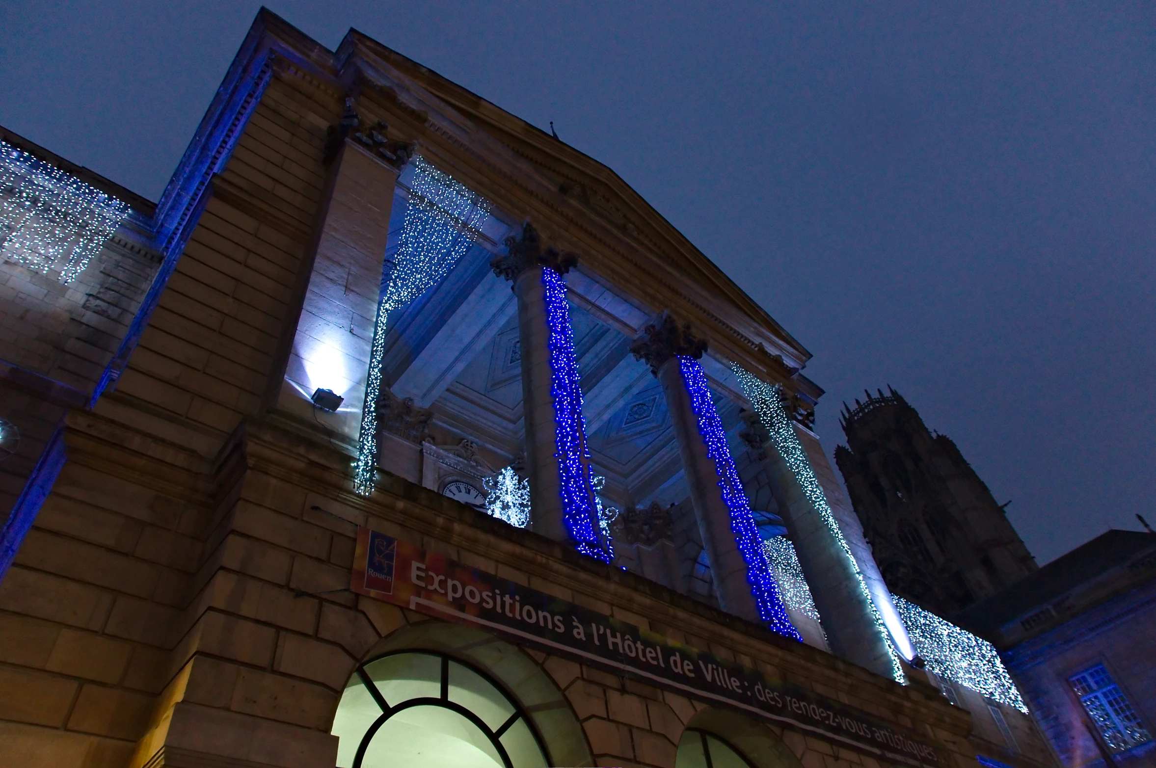 an outdoor theater building has holiday lights on it