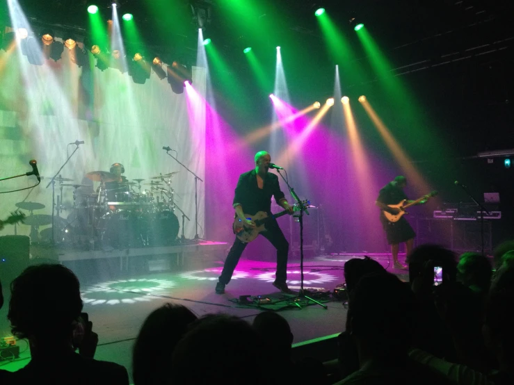 some people on stage with some green and purple lighting