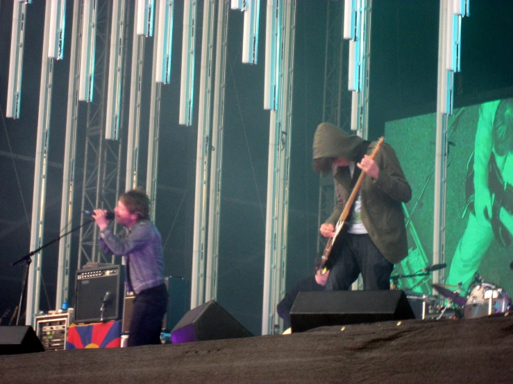 two people on stage one with a guitar