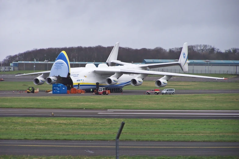 a large airplane is on the ground with several vehicles in front of it