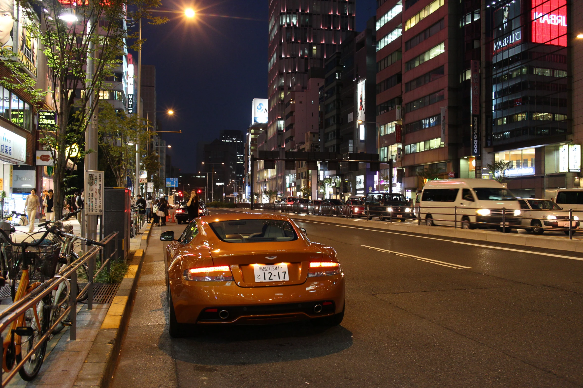 the orange car sits at the front of the busy city street