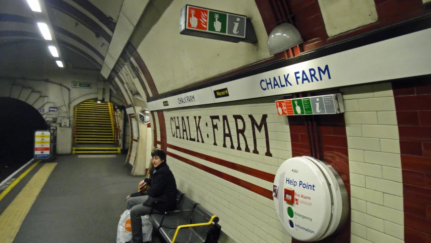 man sitting on bench looking through the subway door