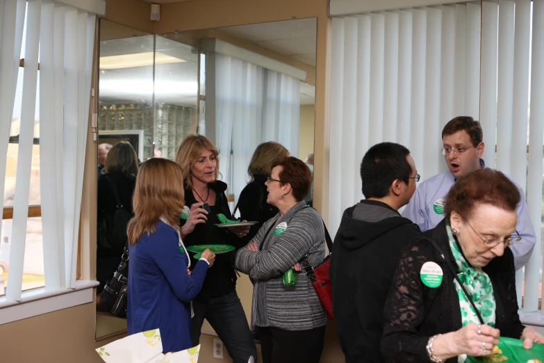 a group of people standing in line looking at green paper