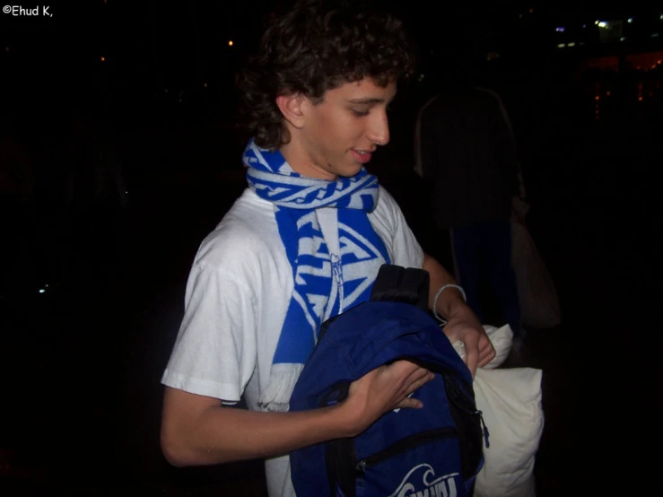 a boy with a blue backpack in the dark