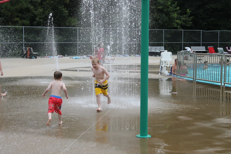 two s play with the fountains in a children's water park