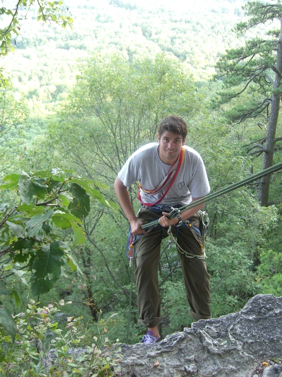 a man climbing a cliff while holding onto an object