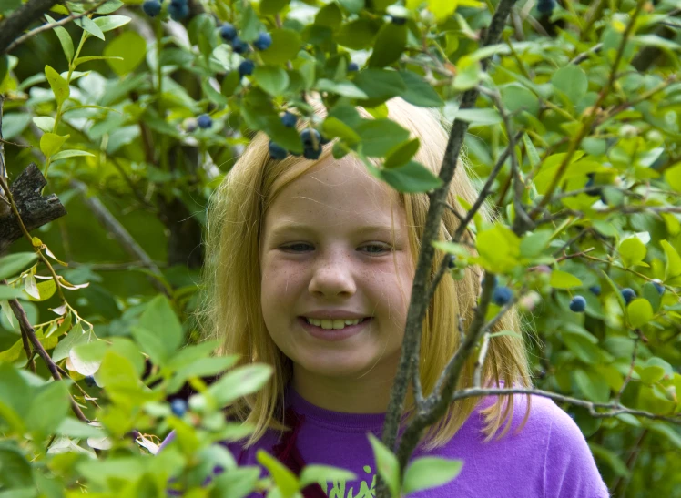 a little girl smiles in the middle of a tree