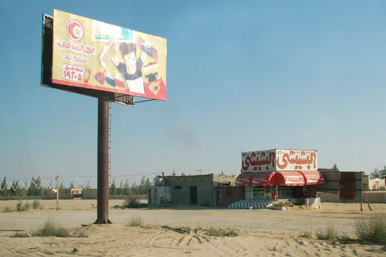 a gas station sign with a business on the top