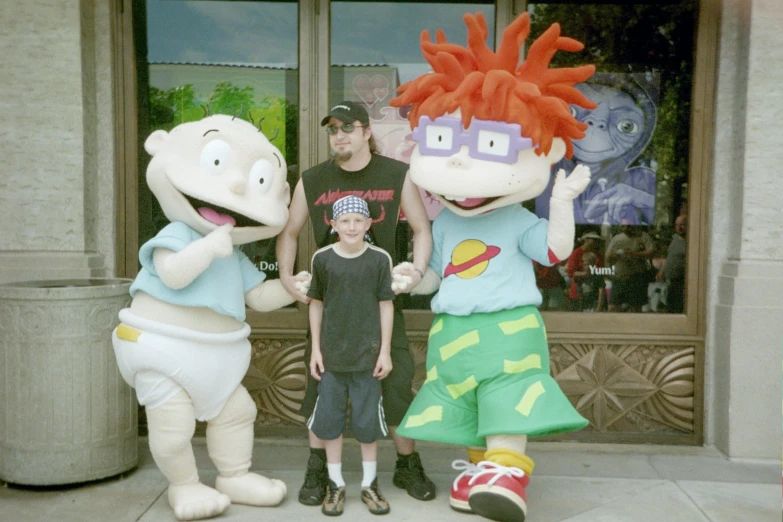a  posing for a picture with the characters behind him