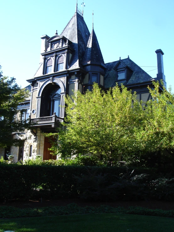 an older victorian building sits above the lush greenery