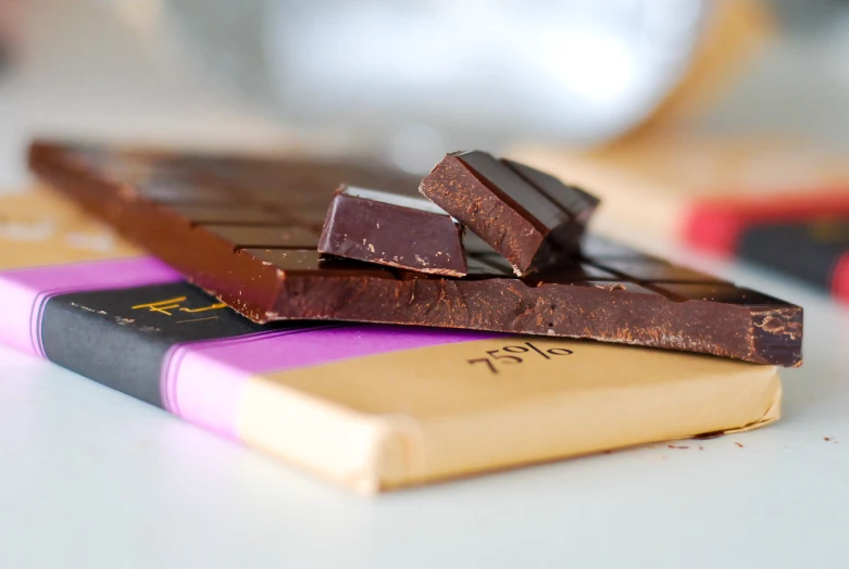 three chocolate bars and one bar of chocolate sitting on top of a book