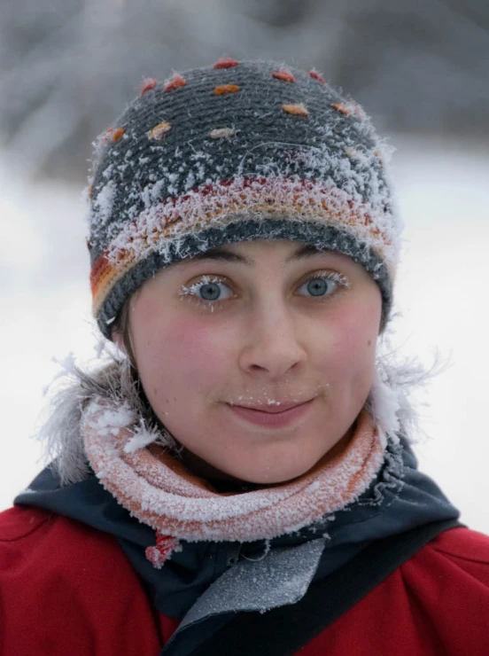 a girl with a winter hat and scarf in the snow