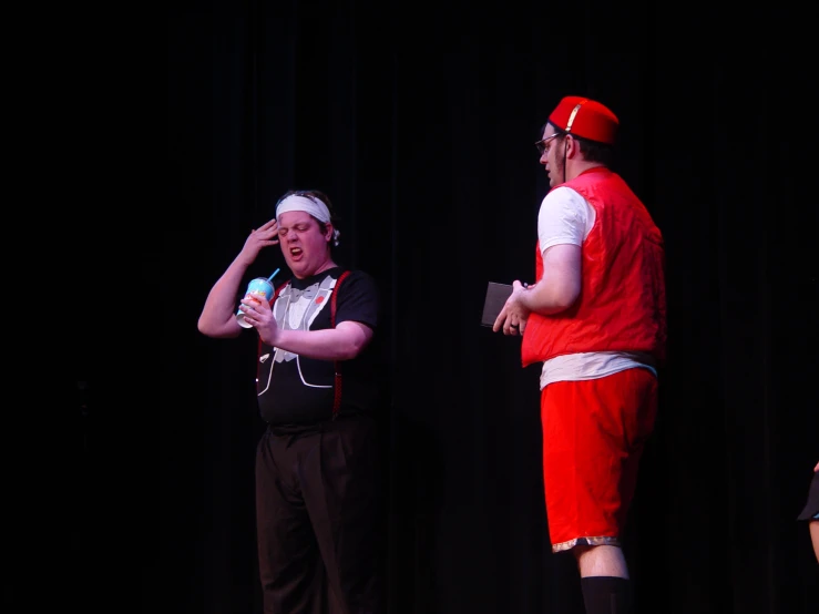 two people standing on stage holding microphones