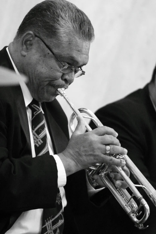 a man plays a trumpet in a black and white po