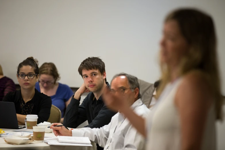 there are people sitting together in a conference room