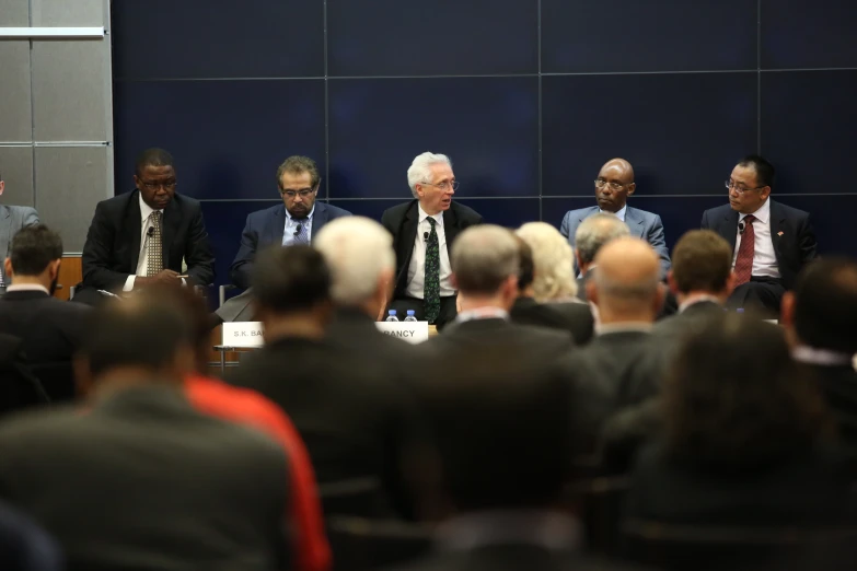 the men in suits and ties are at a table