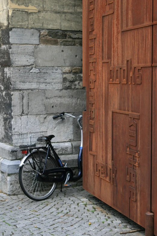 a bike is leaning against a wood door