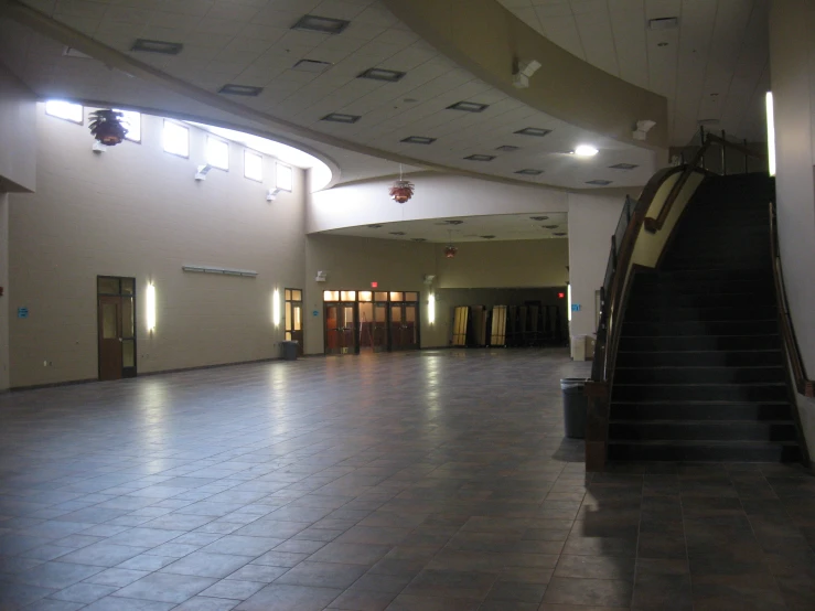 a long hallway leading to multiple elevators with dark steps