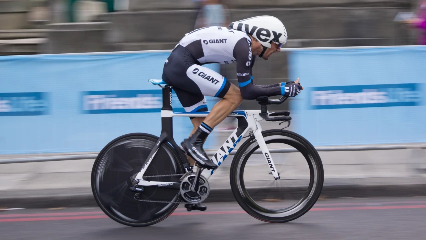 a man riding a bike down a street next to a wall