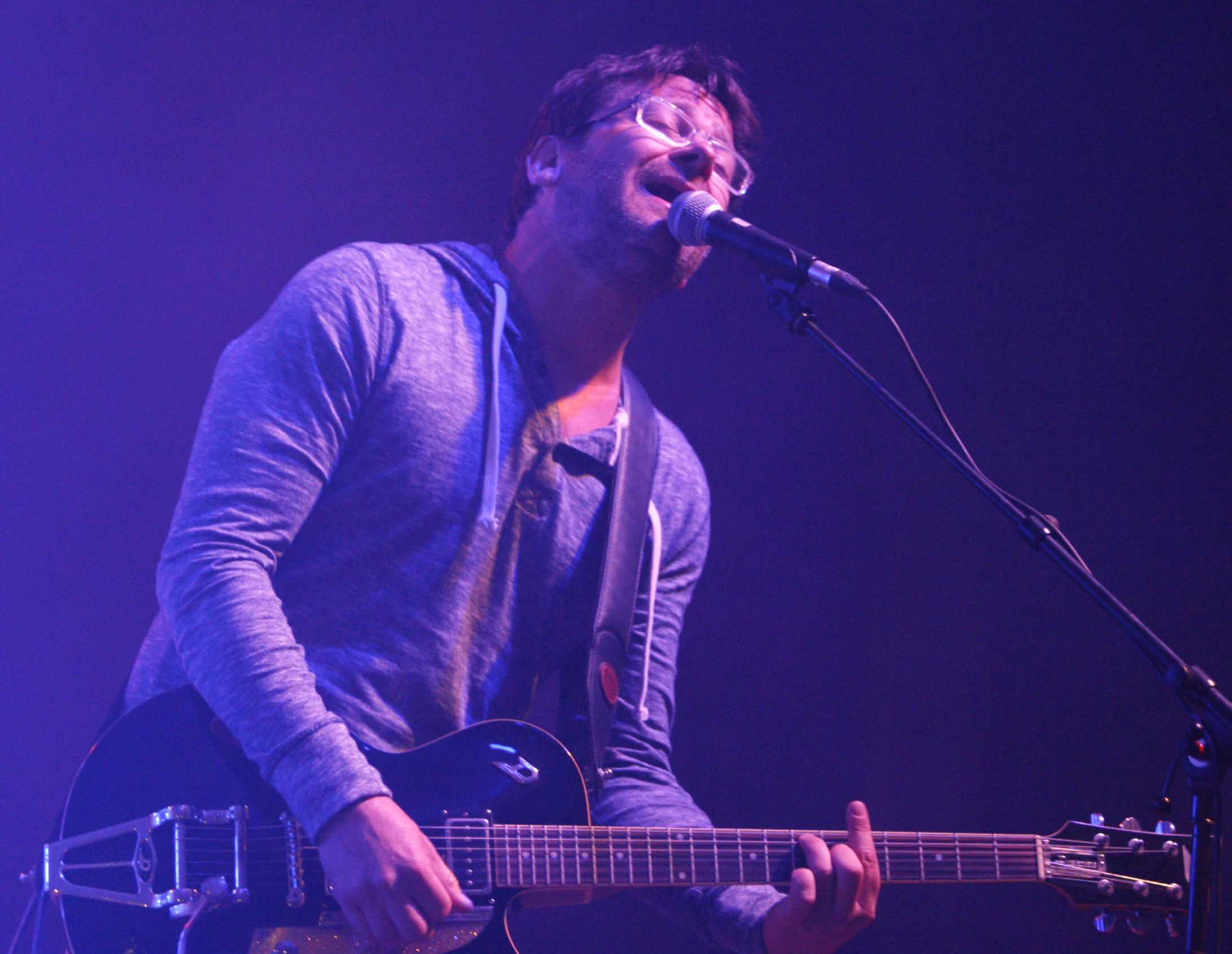 a man is playing his guitar on stage