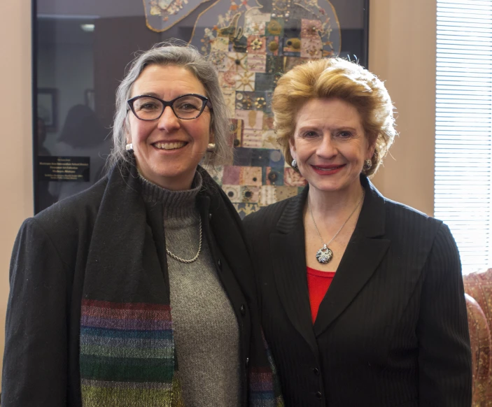 two women stand next to each other in a room