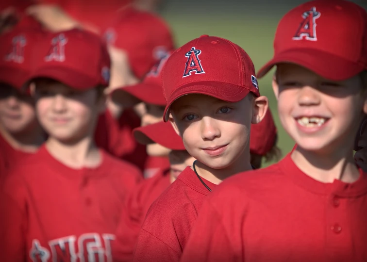 there are young s wearing red uniforms at a baseball game