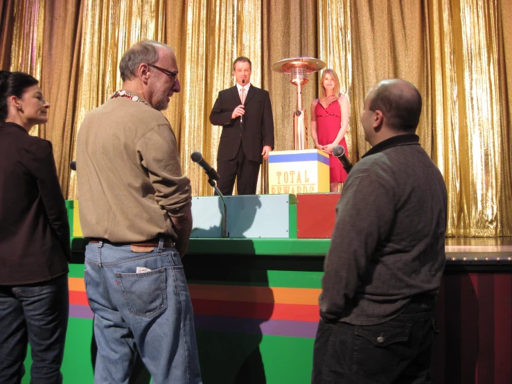 people standing in front of an advertit for a cake