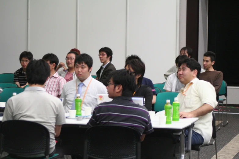 a group of people sitting at tables with cups