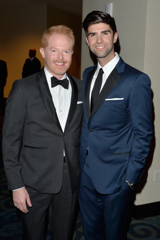 two men in tuxedos posing for the camera