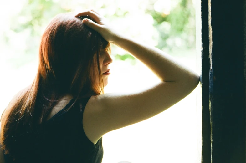 a woman stands in a room in front of an open window