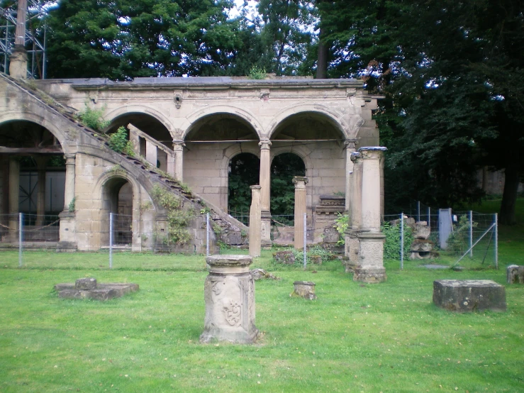 a green lawn with old buildings and graves