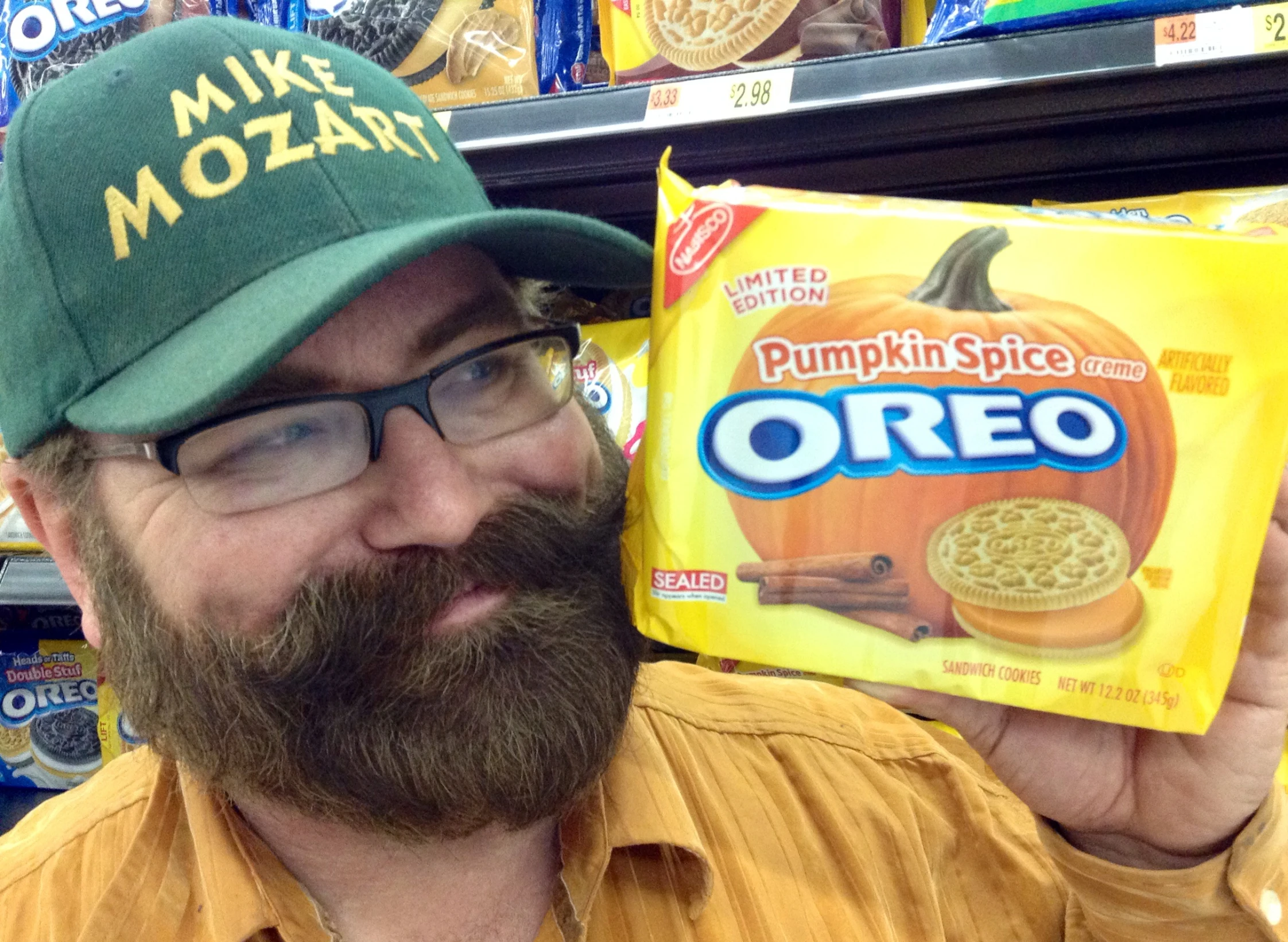 a man wearing a green hat with pumpkin spice is holding a box of oreo