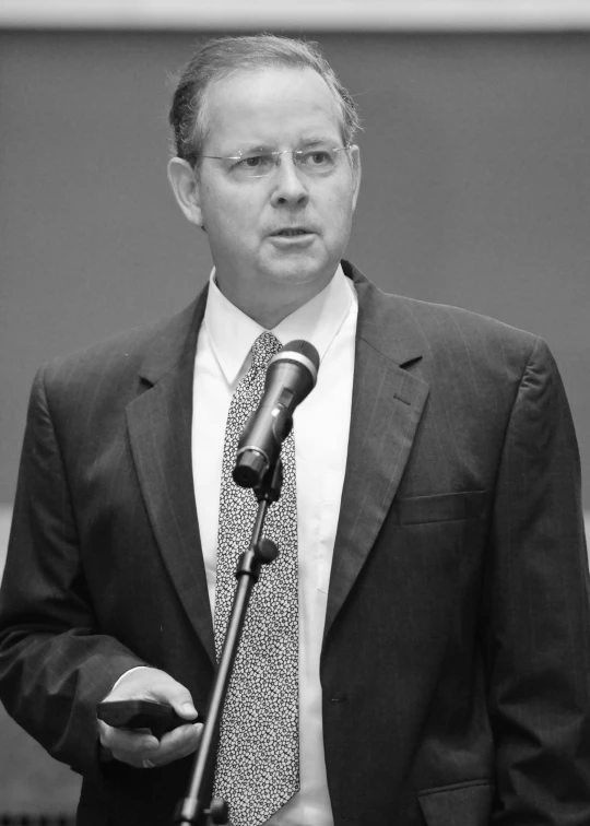 a man in a suit is speaking at a podium