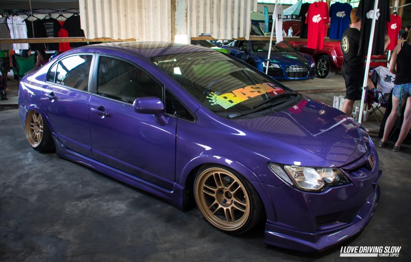 the purple honda civic is on display at an auto show