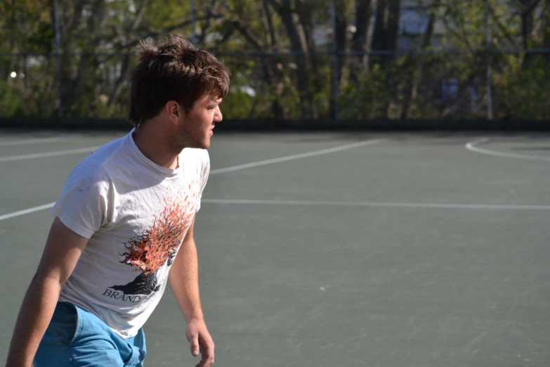 young man on tennis court about to hit ball with racket